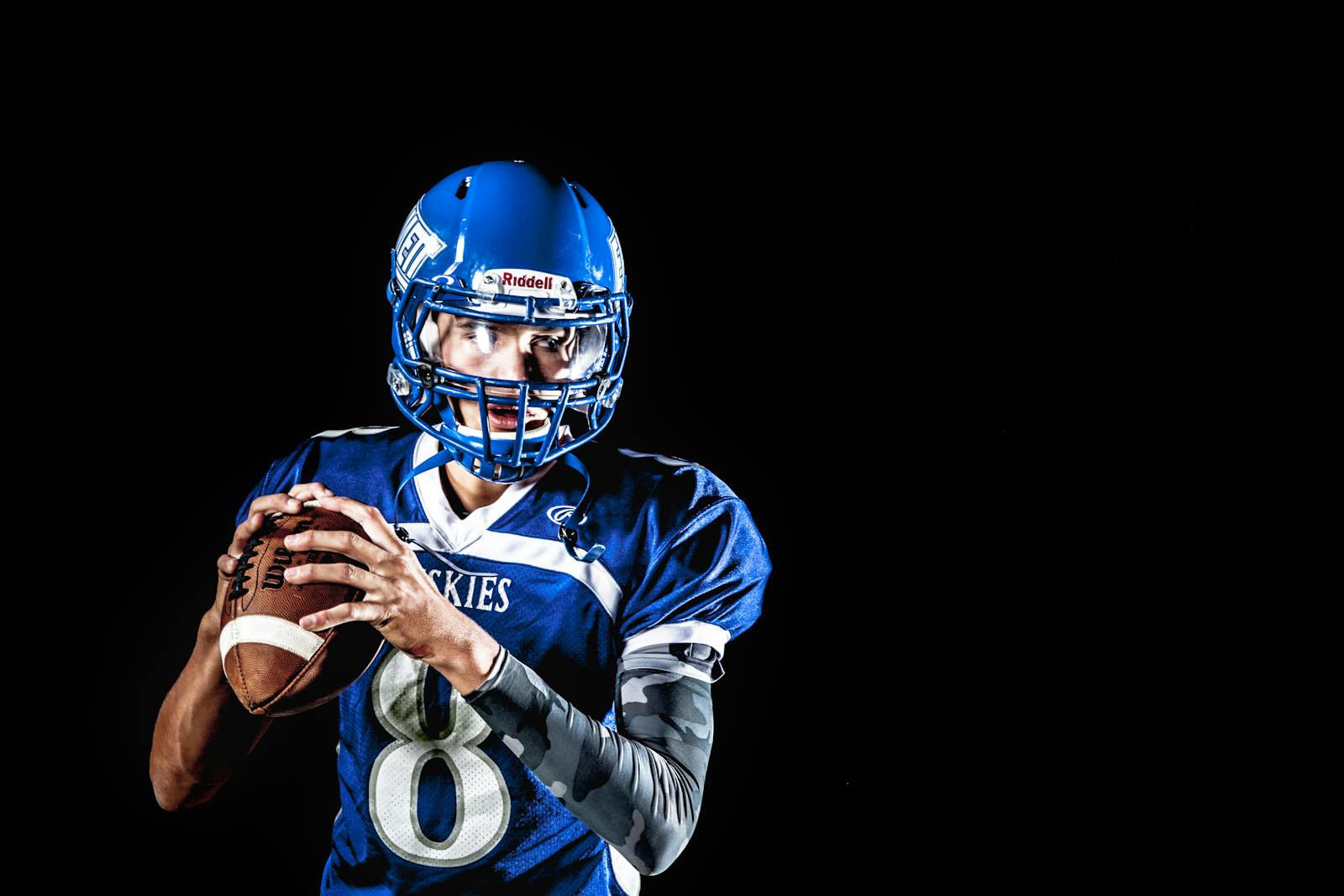 A focused American football quarterback poised to throw during a game.