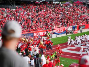 Cheerful fans at a college football game in Houston, TX, showcasing school spirit and vibrant energy.