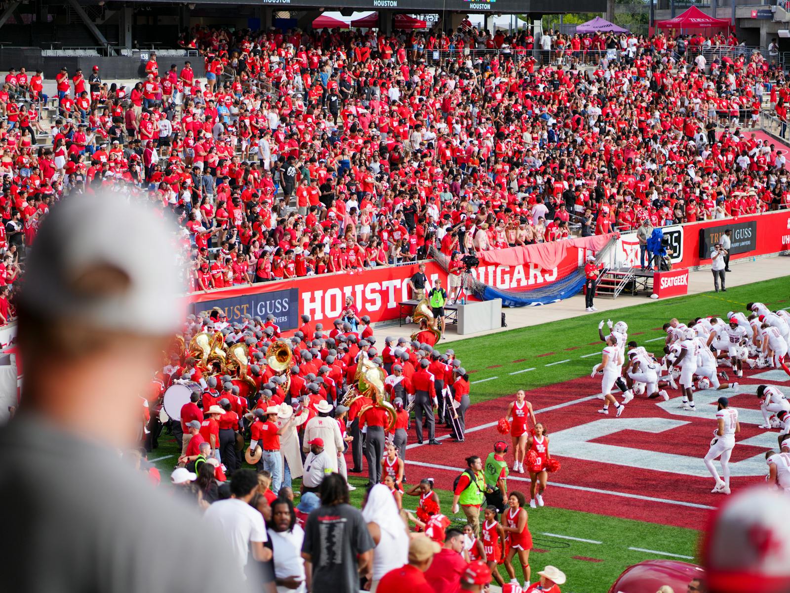 Cheerful fans at a college football game in Houston, TX, showcasing school spirit and vibrant energy.