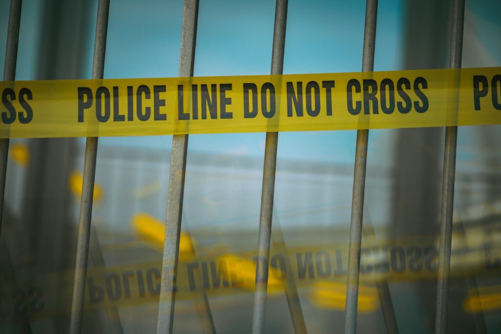 a close up of a yellow police line behind bars